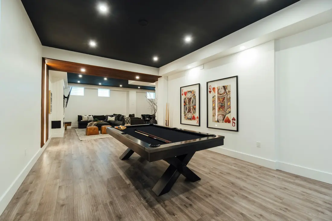 A finished basement games room with a pool table