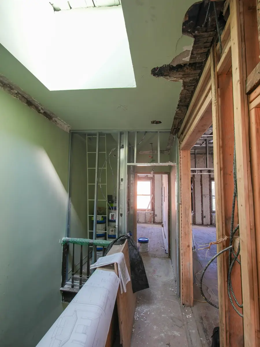 A gutted hallway with new steel studs during a house renovation
