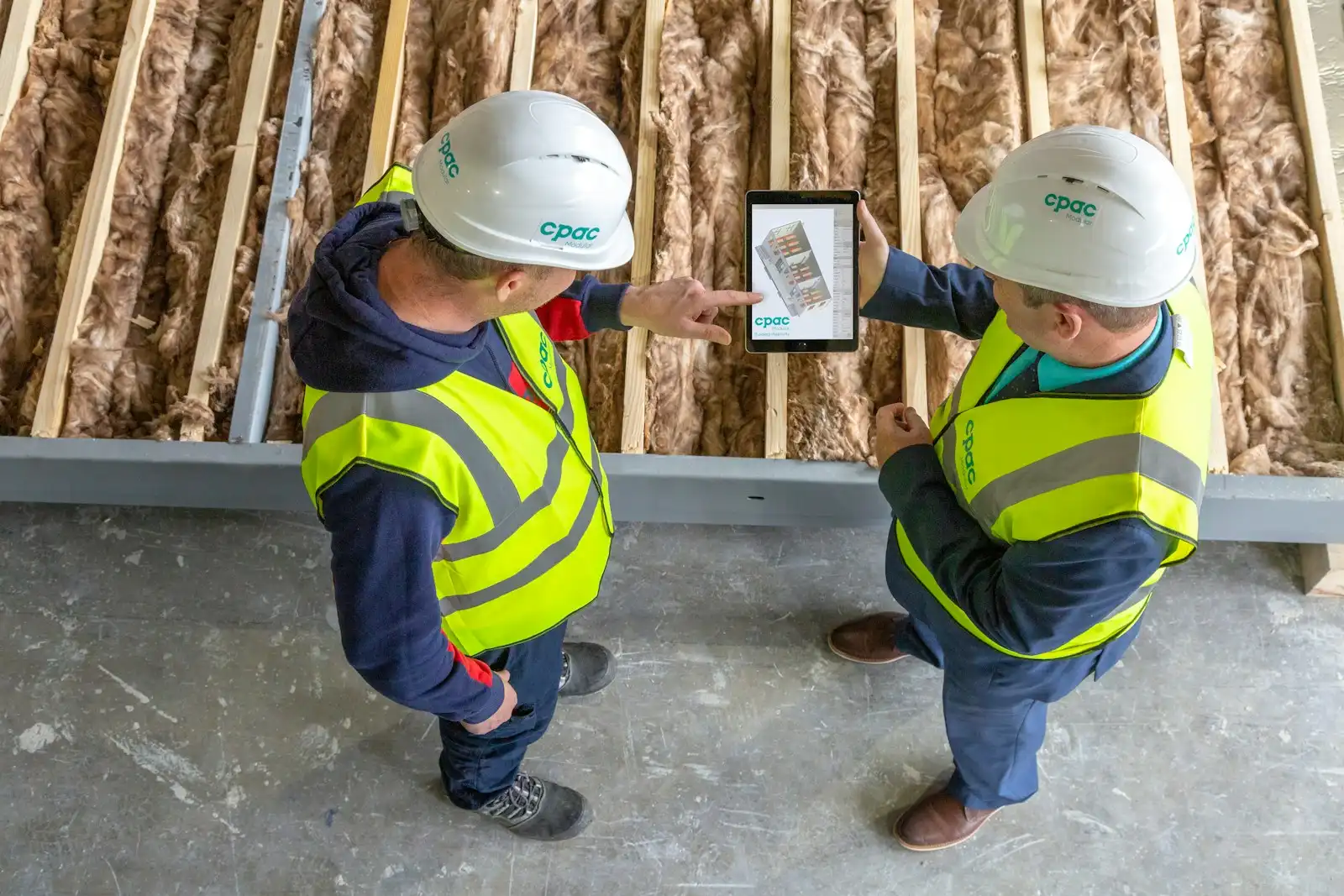 Two workers reviewing plans on site