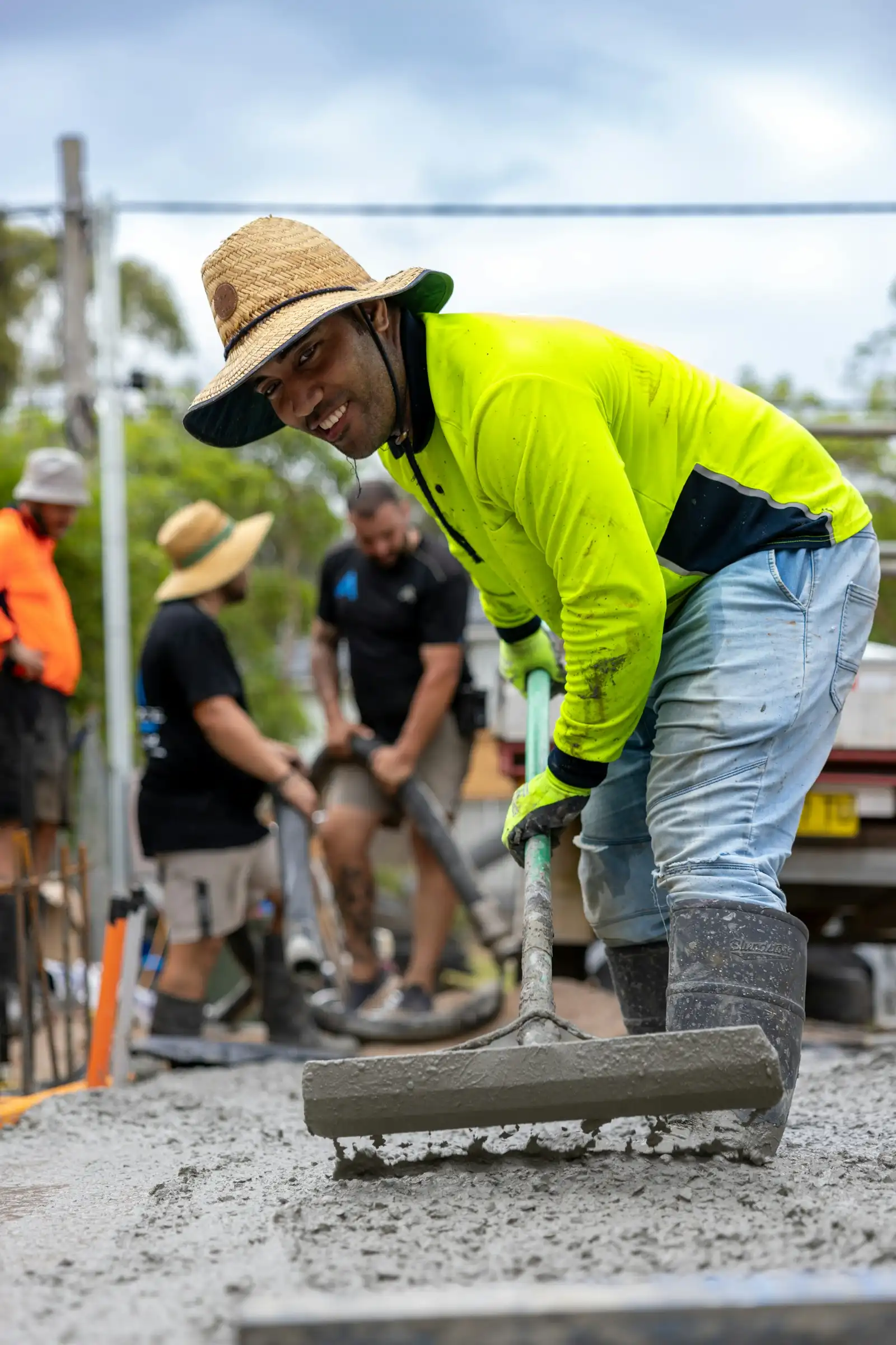 A crew working fresh concrete on a slab