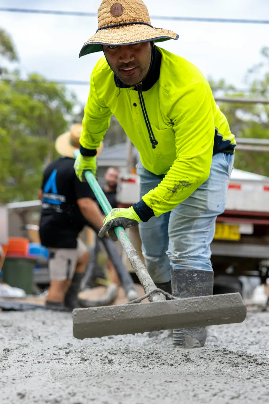 A worker floating fresh concrete on site